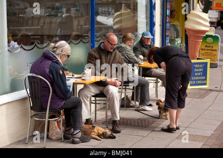 Großbritannien, England, Devon, Brixham Hafen, Kunden mit Hunden trinken Kaffee am Morgen auf dem Bürgersteig Tische Stockfoto