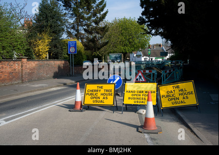 Verkehrszeichen, Zapfen und Barrieren um Baustellen auf einer Straße in England. Stockfoto