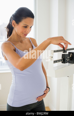 Schwangere Frau im Maßstab Stockfoto