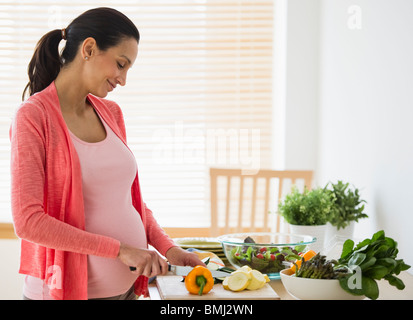Schwangere Frau machen Salat Stockfoto