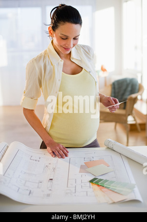 Schwangere Frau betrachten Hauspläne Stockfoto