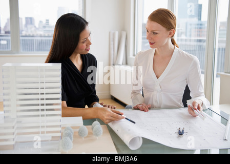 Geschäftsfrauen Blaupausen betrachten Stockfoto