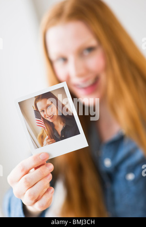 Frau Holding Foto von sich selbst Stockfoto