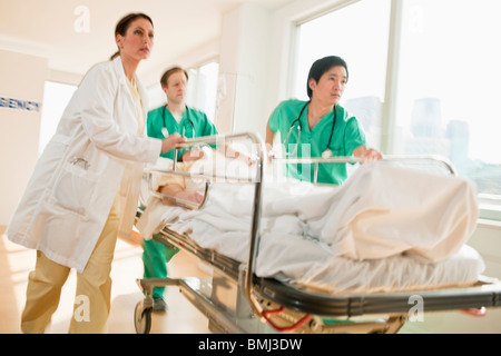 Medizinisches Personal schieben Gurney in Notaufnahme Stockfoto