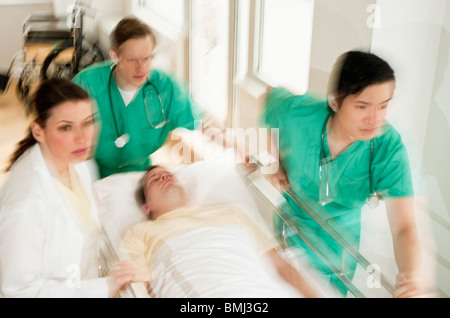 Medizinisches Personal schieben Gurney in Notaufnahme Stockfoto