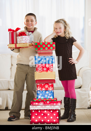 Kleinen Kindern neben einem Stapel von Weihnachtsgeschenke Stockfoto