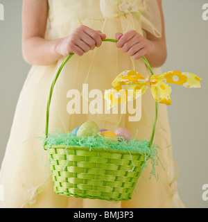 Junges Mädchen hält einen Korb mit Ostereiern Stockfoto