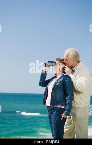Paar auf der Suche am Ozean mit dem Fernglas Stockfoto