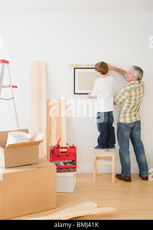 Vater und Sohn hängenden Bild an Wand Stockfoto