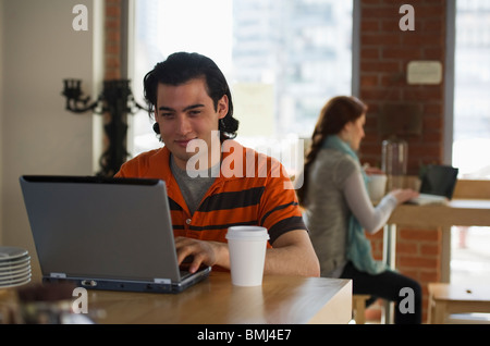 Mann arbeitet am Laptop in Coffee-shop Stockfoto