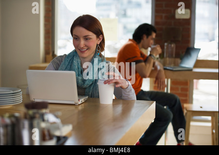 Frau arbeitet am Laptop in Coffee-shop Stockfoto