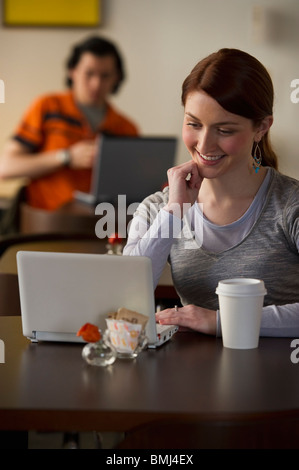 Frau arbeitet am Laptop in Coffee-shop Stockfoto