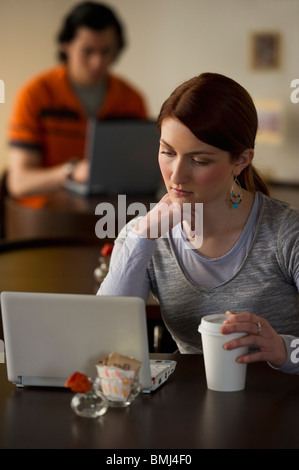 Frau arbeitet am Laptop in Coffee-shop Stockfoto