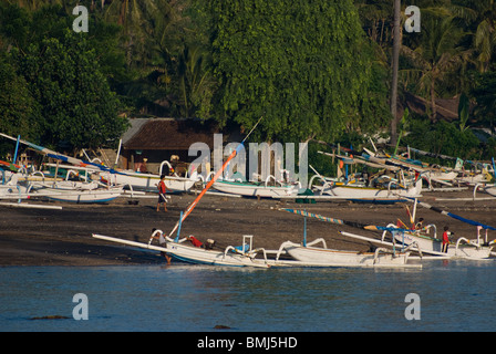 In dem Dorf Amed hochziehen Bali Fischer Boote genannt Jukung am Strand nach einer durchzechten Nacht Angeln für Makrele. Stockfoto