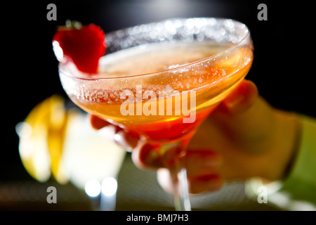 Womans Hand halten Erdbeer Bellini cocktail in einer bar Stockfoto