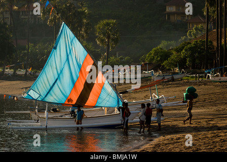 Eine balinesische Angeln Auslegerboot, genannt eine Jukung kehrt zurück zum Ufer in Amed, Bali, nach einer Nacht von trolling für Fische. Stockfoto