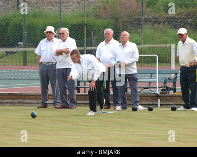 Junger Mann spielen Schalen mit einer Gruppe von alten Männern, Bude, Cornwall Stockfoto