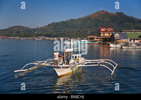 Ein kleines Boot und Stadt CORON auf BUSUANGA ISLAND in der CALAMIAN Gruppe - Philippinen Stockfoto