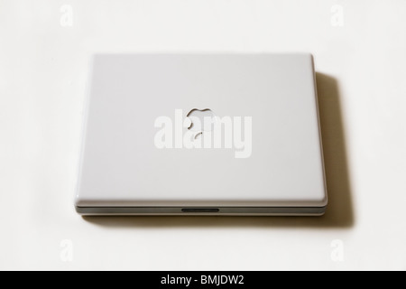 Ein geschlossener Apple iBook G4 Notebook / Laptop zeigt das Apple-Logo. Stockfoto