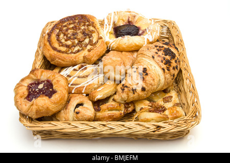 Weidenkorb mit Auswahl an französischen & dänische Gebäck auf weißem Hintergrund. Stockfoto