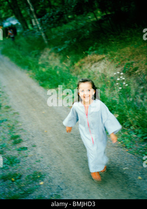 Ein lachendes Mädchen laufen auf einer Straße, Schweden. Stockfoto