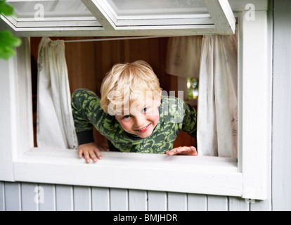 Junge spielt im Fenster Stockfoto