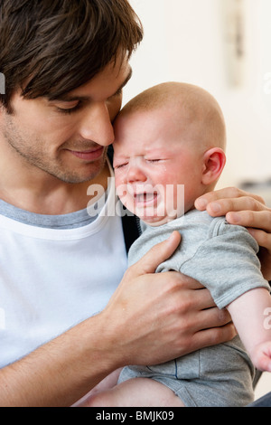 Vater Holding schreiendes baby Stockfoto