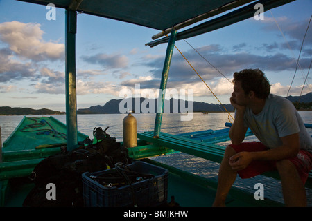 Sonnenuntergang und unser kleines Boot in der Nähe von BUSUANGA ISLAND in der CALAMIAN Gruppe - Philippinen Stockfoto