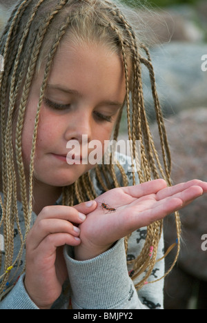 Skandinavien, Schweden, Smaland, Mädchen (6-7) mit Holding-Bug auf Palm, Nahaufnahme Stockfoto