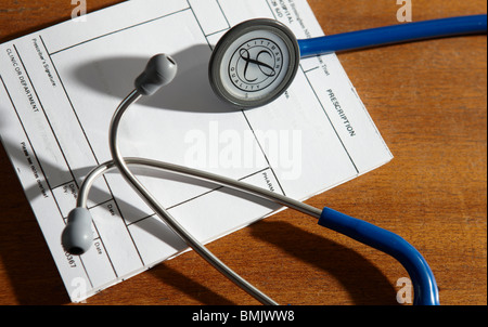 Eine Ärzte-Stethoskop ruht auf einem Rezept-Pad in eine Ärzte-Chirurgie. Stockfoto