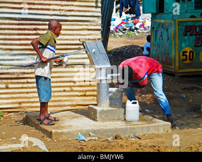 Haitianische Kinder trinken Trinkwasser aus einer Pumpe n Ouanaminthe, haiti Stockfoto