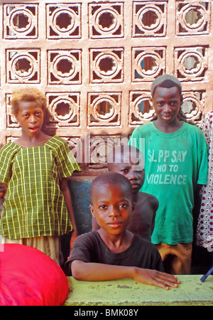 Kinder im Dorf von Tombo, Sierra Leone. Man trägt ein T-shirt "SLPP sagen Nein zu Gewalt". (Sierra Leone Peoples Party) Stockfoto