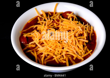 Chili mit Fleisch Würstchen und Käse isoliert auf schwarz Stockfoto