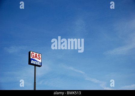 Tankstelle Schild mit den Worten Benzin und Diesel an einem langen Mast gegen blauen Himmel. Stockfoto