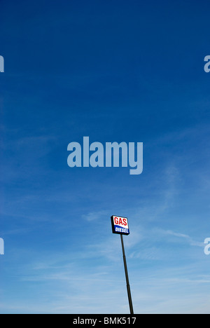 Tankstelle Schild mit den Worten Benzin und Diesel an einem langen Mast gegen blauen Himmel.