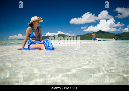 Ein Mann und eine Frau an einem Strand eine tahitian Hotelanlage mit Schnorchelausrüstung (Flossen und Maske). Sie sind auf Sand Sonnenbaden. Stockfoto