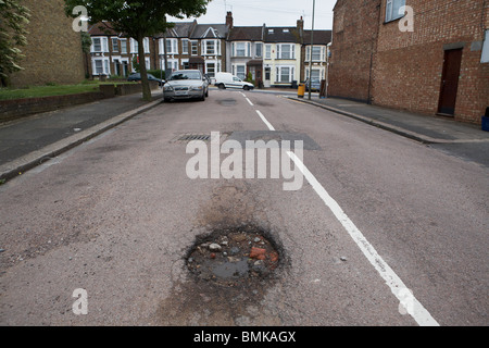 Schlaglöcher in einer Vorstadt Straße in Nord-London Stockfoto