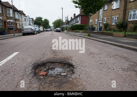 Schlaglöcher in einer Vorstadt Straße in Nord-London Stockfoto