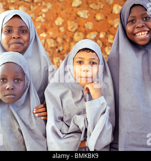 Junge afrikanische muslimische Mädchen in Kenia traditionelle muslimische Madrasa Uniformen steht man vor einer Lehmhütte in Stockfoto