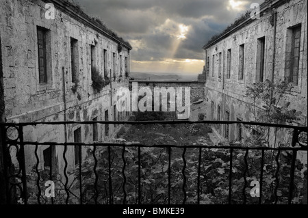 Verkommen Militärgefängnis Gebäude Festung La Mola, Mahon (Mao) Menorca, Spanien. Ein finsterer Ort und ein bedrohlicher Himmel Stockfoto