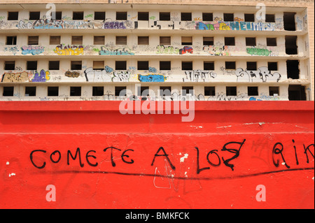 Umfangreiche graffiti auf marode Straßenzug von Wohnungen, Mahon, Menorca, Spanien. Muster der Reihen von Fenstern und hellen roten Barriere Stockfoto