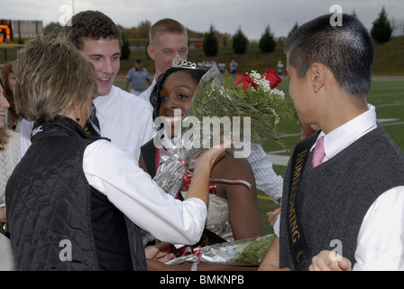 Mädchen erhält ein Strauß Rosen nach war sie gekrönt Homecoming Queen an einer High School Homecoming Fußballspiel Stockfoto