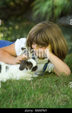 Junges Mädchen im Gras streicheln ihr Hase Stockfoto