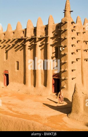 Ein Mann geht vorbei an einer Seitentür der Moschee von Djenné, ein klassisches Beispiel der Sahel-Architektur, Stockfoto