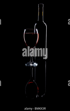Flasche Rotwein mit Glas gefüllt mit Wein auf dem schwarzen Hintergrund Studio gedreht. Stockfoto