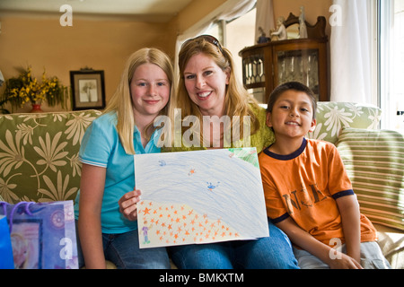 Die interracial Muttertag 11 Jahre alte Tochter und nahm 8 Jahre alten Mexikanischen Hispanischen Sohn auf Kamera vorhanden Geschenke Geschenk Geschenke HERR © Myrleen Pearson Stockfoto