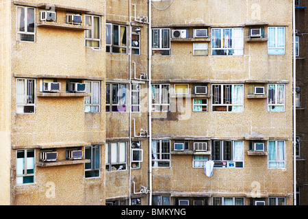 Rückansicht des Wohnblocks in Hong Kong, zeigt im Alter von Fliesen, Wand, Abflussrohre, schmutzige Klimaanlage und Wäscheleinen Stockfoto