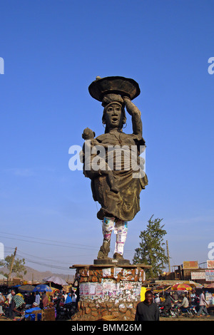 Jos, Nigeria, Statue, eine Frau und ihr Baby in den Arm, mit Werbeplakaten darstellt, die auf ihre Beine stecken Stockfoto