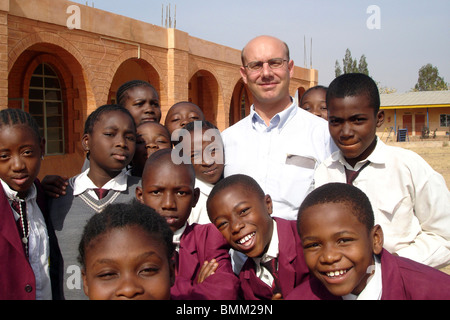 Nigeria, Jos, französischer Direktor der Schule und seine Schüler auf dem Schulhof. Stockfoto