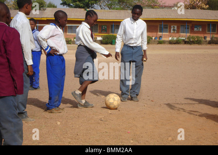 Schüler in ihrer Schuluniform Fußball zu spielen. Stockfoto